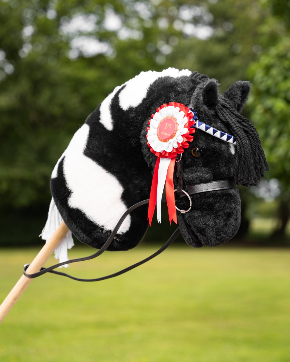 Black Coloured LeMieux Hobby Horse Showing Bridle On A Outer Yard Background