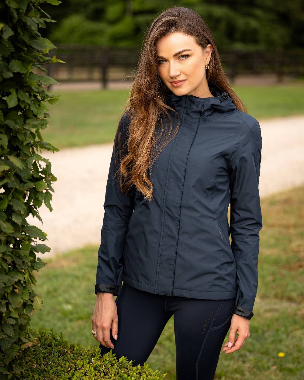 Navy coloured LeMieux Isla Short Waterproof Jacket on green background 