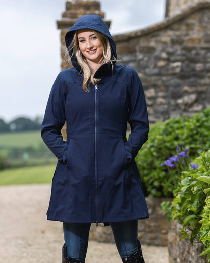 Navy coloured LeMieux Maisie Lightweight Riding Jacket with plants in background 