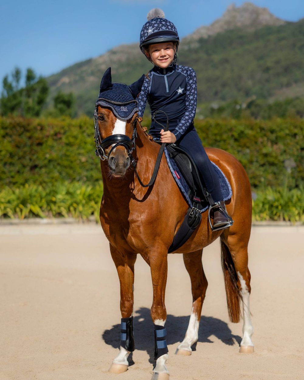 Indigo coloured LeMieux Mini Base Layers on mountain background 