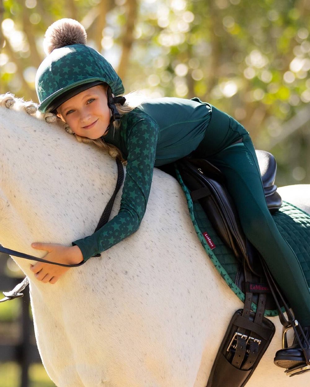 Spruce coloured LeMieux Mini Base Layers on blurry green background 