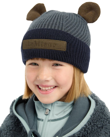 Petrol Coloured LeMieux Mini Bear Beanie On A Street Background 