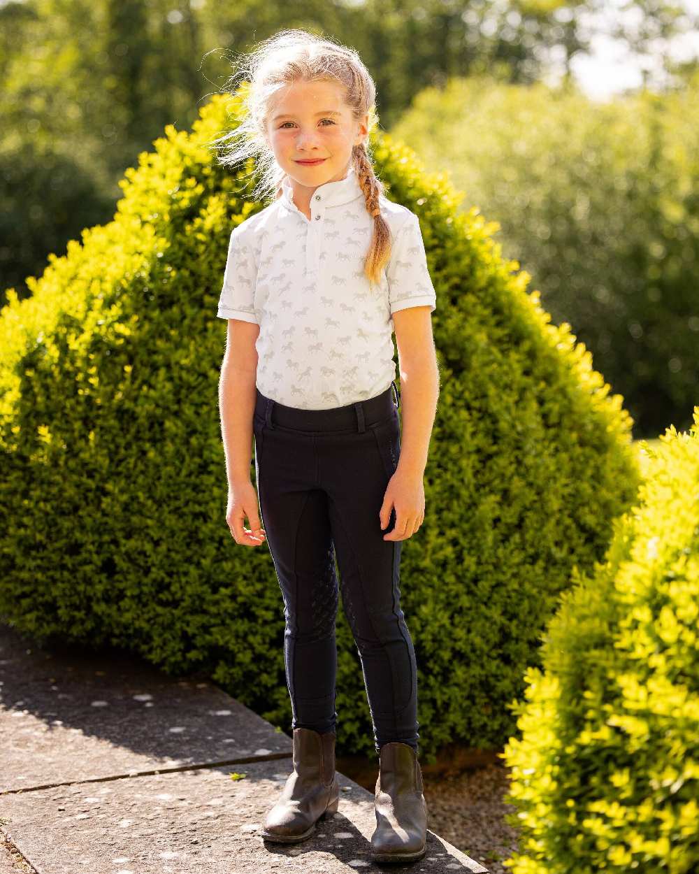 White coloured LeMieux Mini Bella Show Shirt green bush in background 