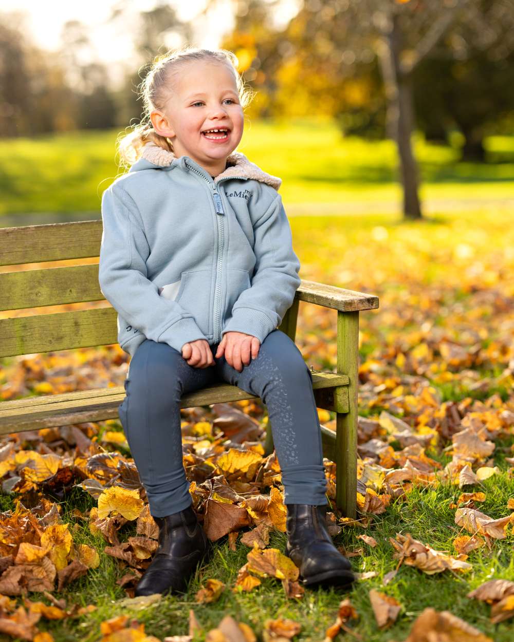 Glacier Coloured LeMieux Mini Charlie Lined Hoodie On A Outer Yard Background 