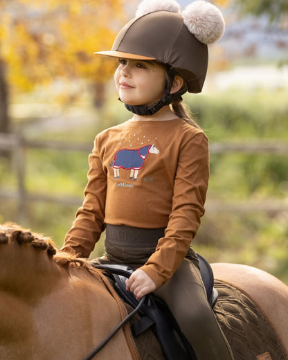 Ginger Coloured LeMieux Mini Jessie Long Sleeve Top On A Outer Yard Background 