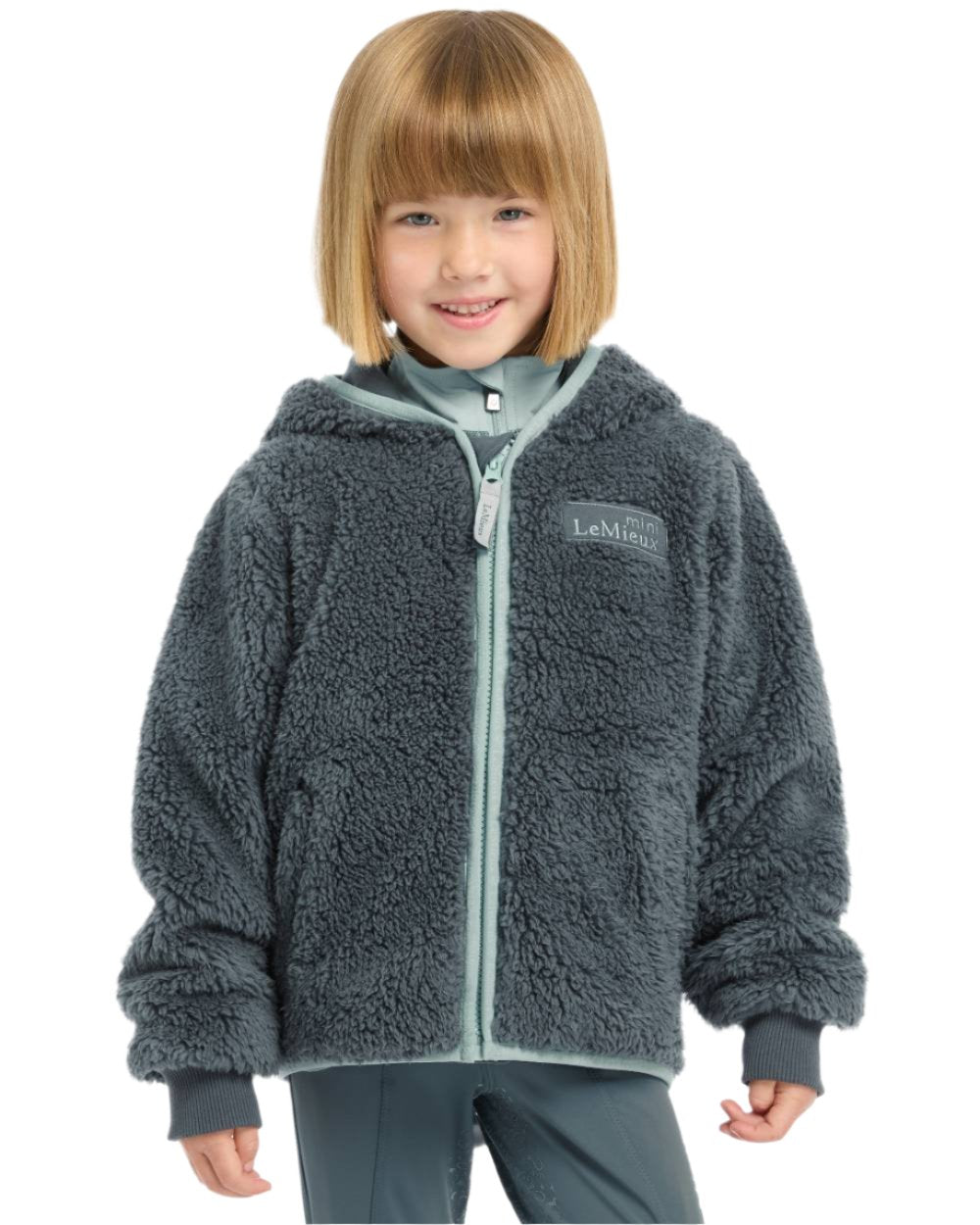 Petrol Coloured LeMieux Mini Teagan Fleece Jacket On A White Background 