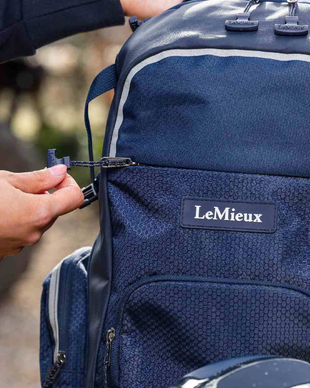 Navy coloured LeMieux Pro Rucksack on blurry background 