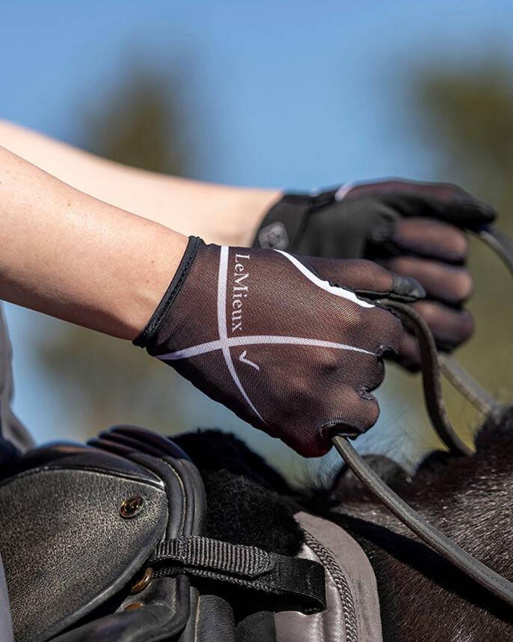 Black coloured LeMieux Soleil Mesh Riding Gloves on blurry background 