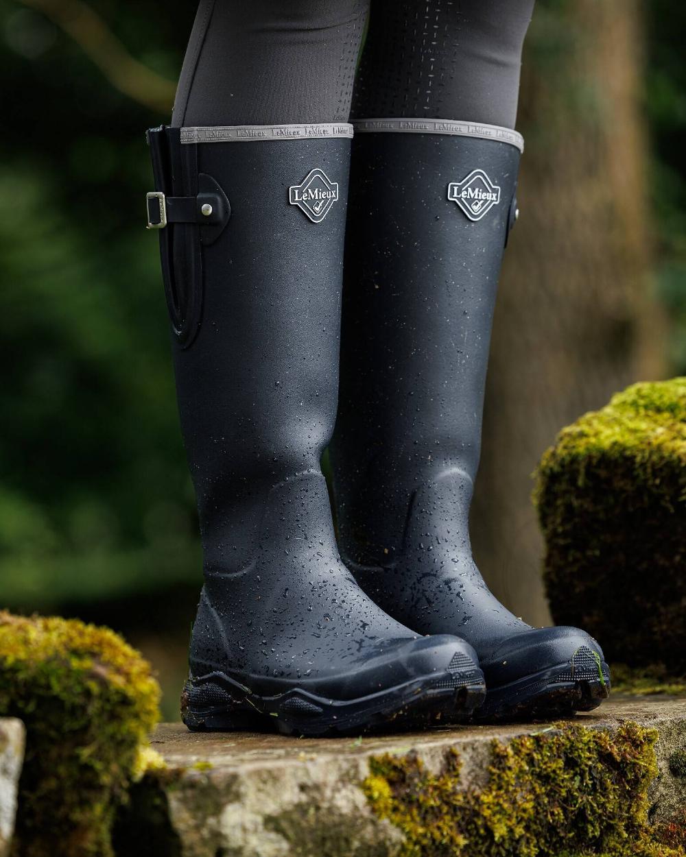 Navy coloured LeMieux Stride Wellington Boots on forest background 