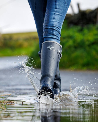 Navy coloured LeMieux Stride Wellington Boots on water background 