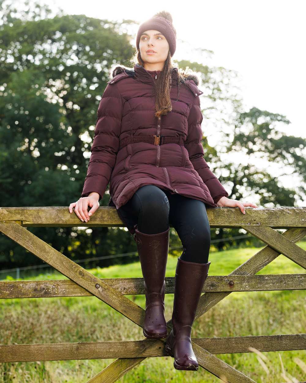 Port coloured LeMieux Stride Wellington Boots with fence in background 