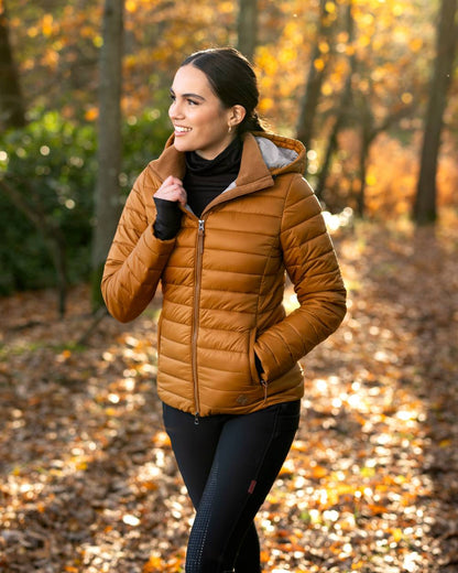 Ginger Coloured LeMieux Tilly Hooded Puffer Jacket On A Forest Background 