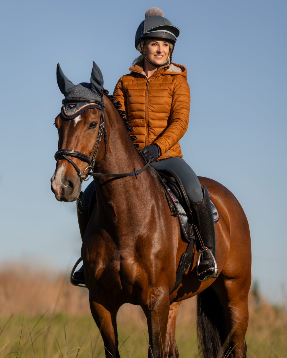 Ginger Coloured LeMieux Tilly Hooded Puffer Jacket On A Forest Background 