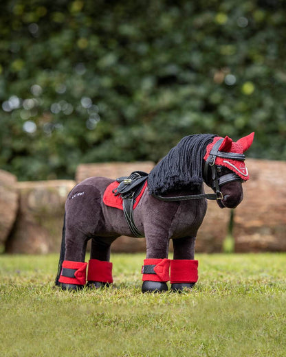 Chilli coloured LeMieux Toy Pony Bandages on grassy background 