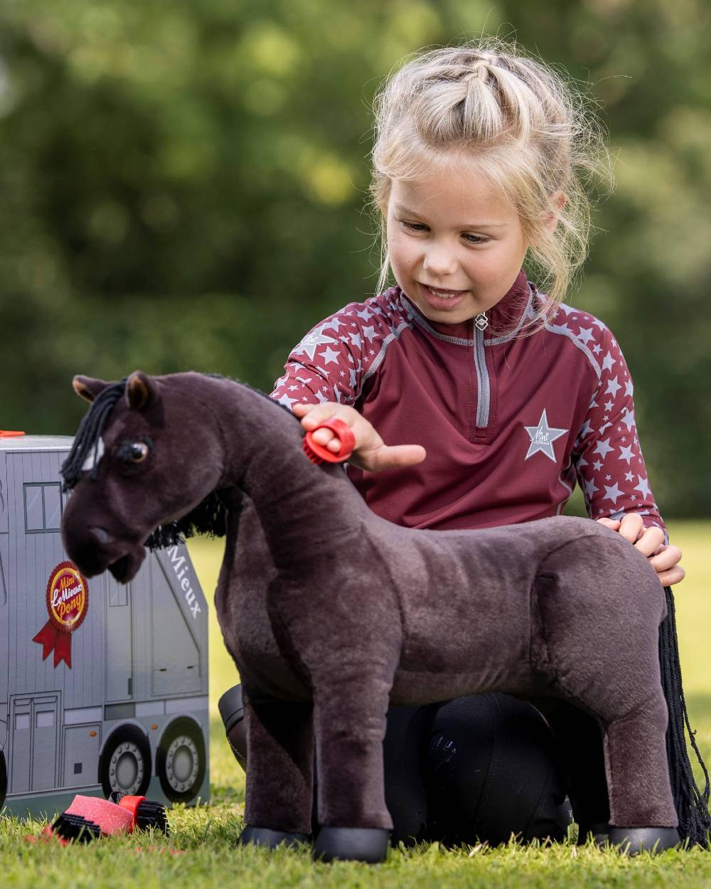 Ember Coloured LeMieux Toy Pony Grooming Kit On A Outer Yard Background 