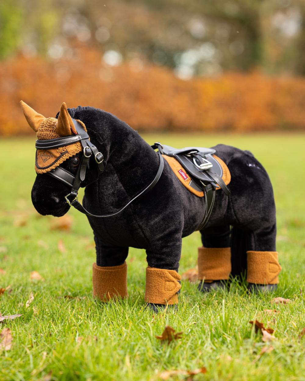 Ginger Coloured LeMieux Toy Pony Pad On A Outer Yard Background 