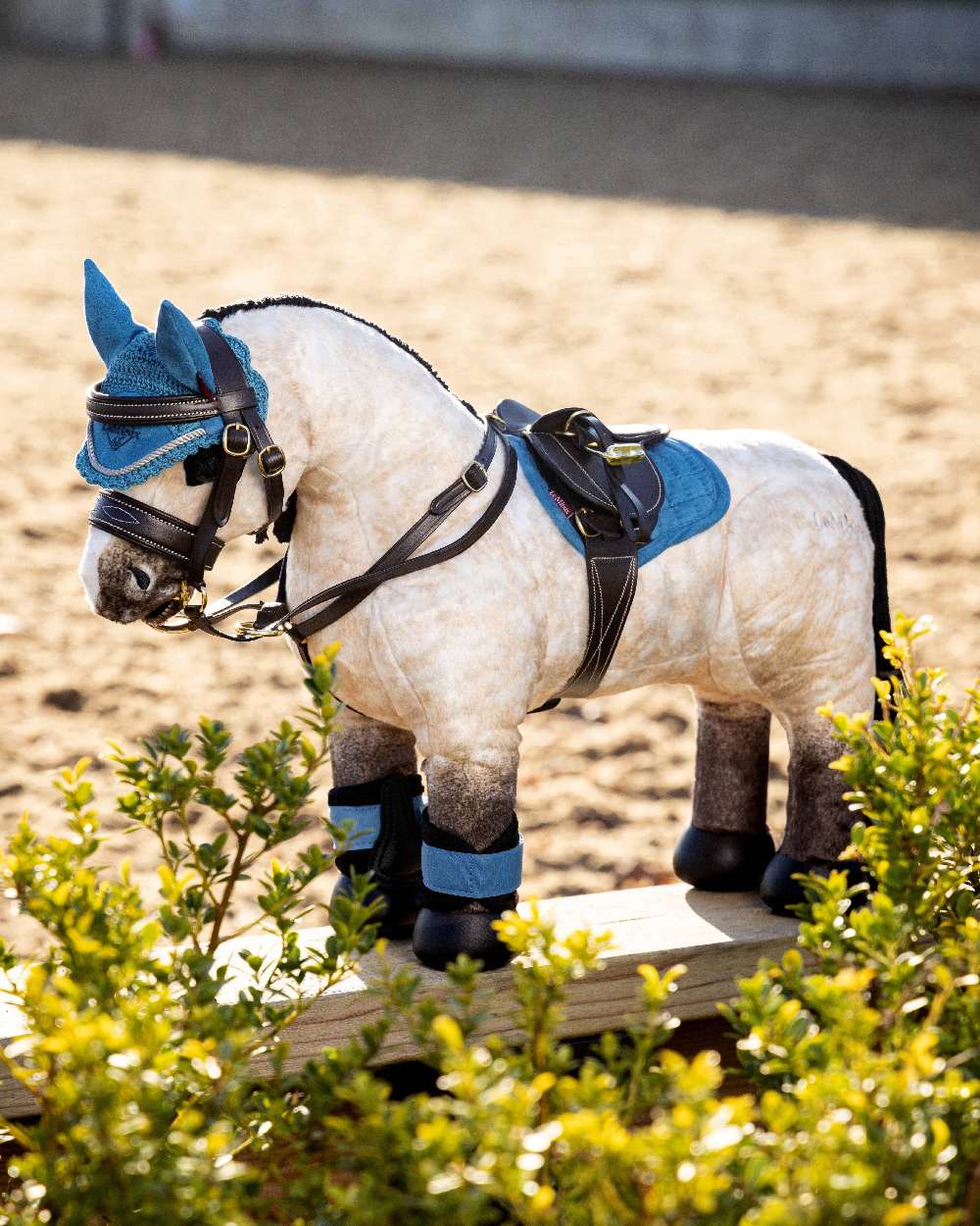 Black coloured LeMieux Toy Pony Saddle on blurred pen background 