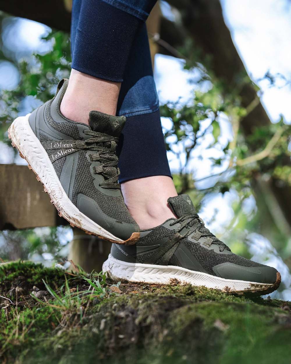 Khaki coloured LeMieux Trax Waterproof Trainers on blurry green background 