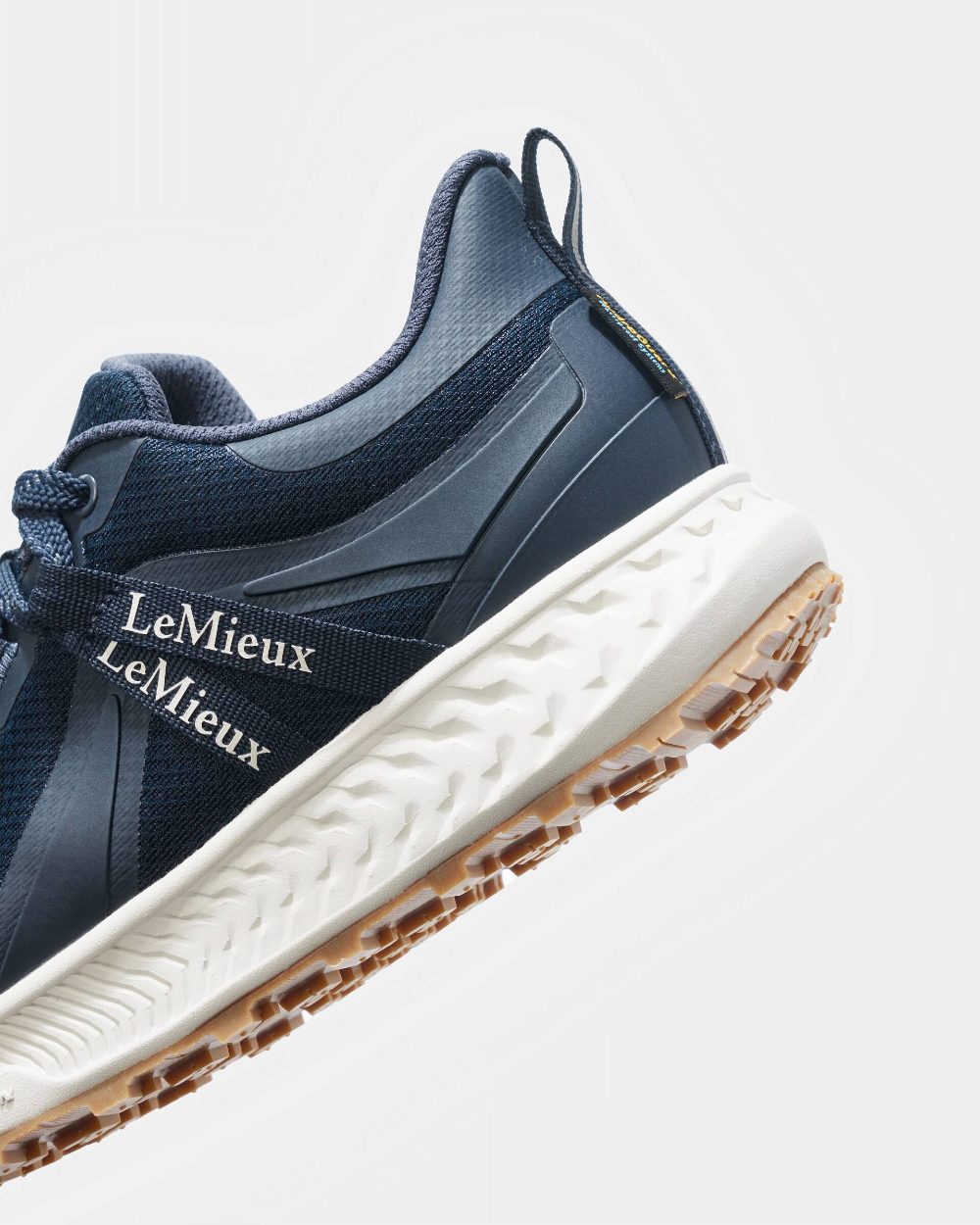 Navy coloured LeMieux Trax Waterproof Trainers on grey background 