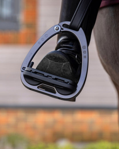 Carbon coloured LeMieux Vector Balance Stirrup on blurry background 