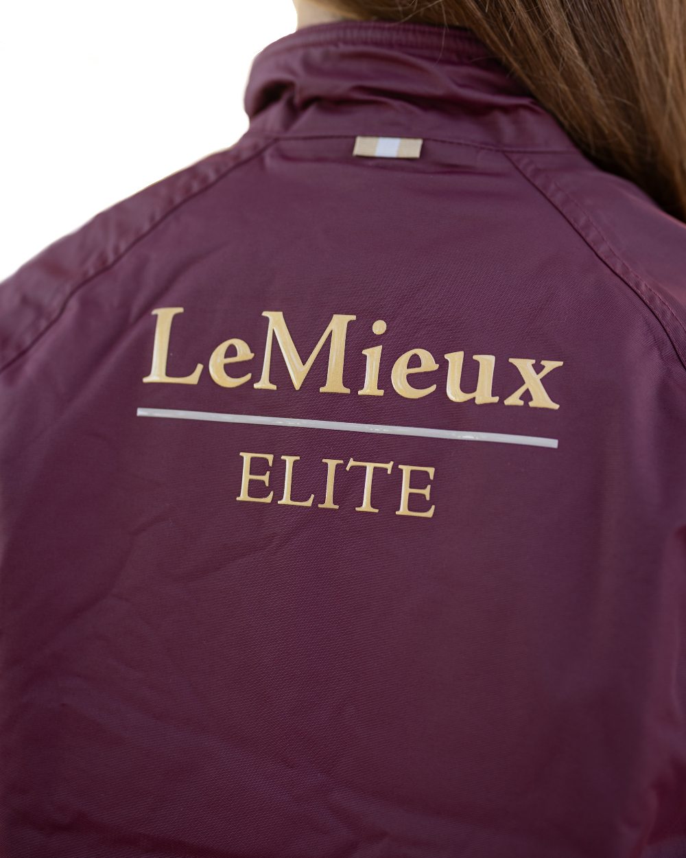 Burgundy coloured LeMieux Young Rider Elite Team Jacket on white background 