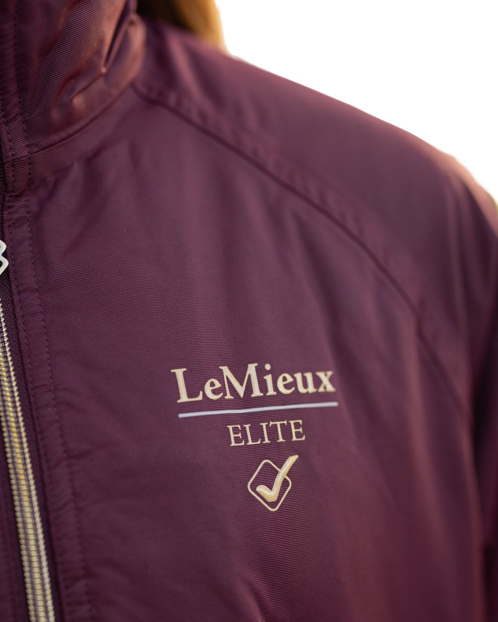 Burgundy coloured LeMieux Young Rider Elite Team Jacket on white background 