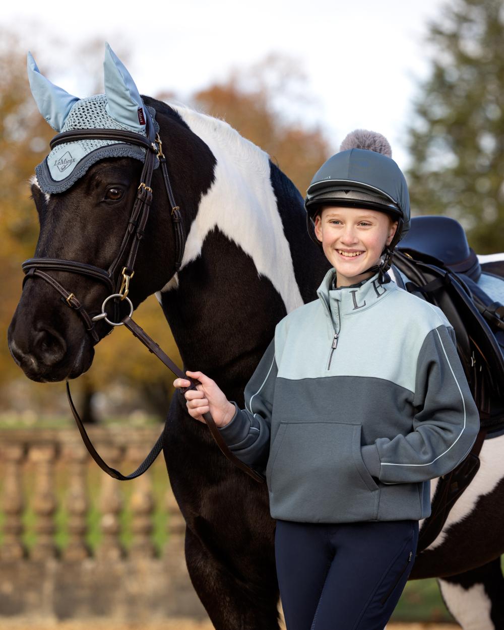 Petrol Glacier Coloured LeMieux Young Rider Kate Quarter Zip Sweater On A Outer Yard Background 