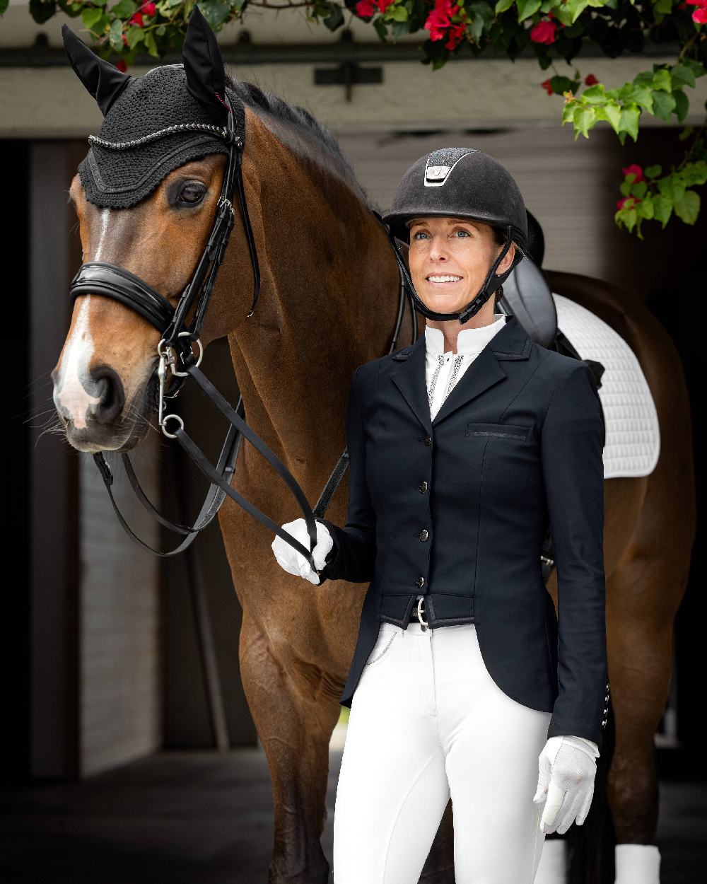 Black coloured LeMieux Zoe Show Jacket on blurry building background 