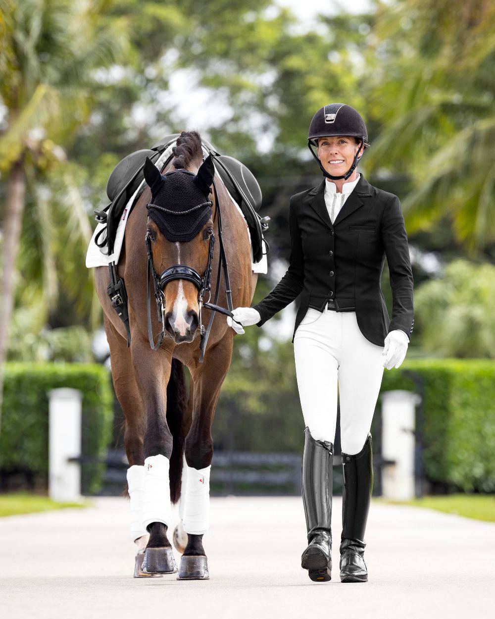 Black coloured LeMieux Zoe Show Jacket on blurry tree background 