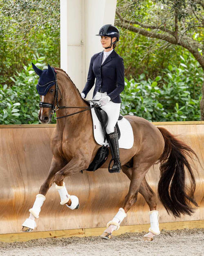 Navy coloured LeMieux Zoe Show Jacket with trees in background 