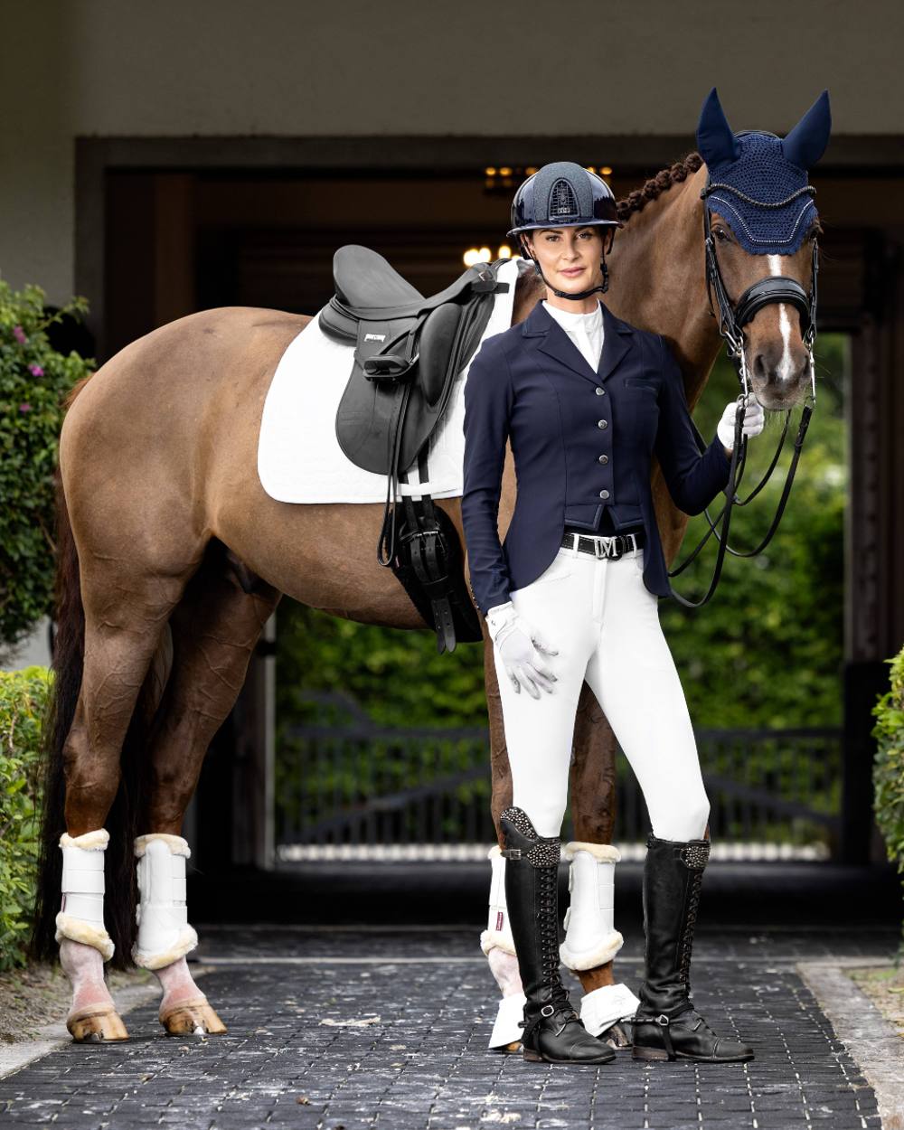 Navy coloured LeMieux Zoe Show Jacket on blurry building background 