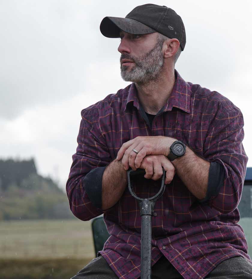 Work shirts with two chest pockets. Man wears red plaid shirt and peaked cap.