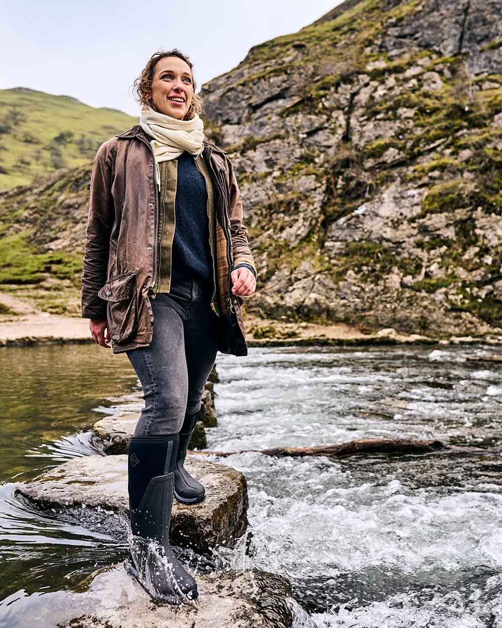 Black coloured Muck Boots Womens Artic Sport II Tall Wellingtons on River background 