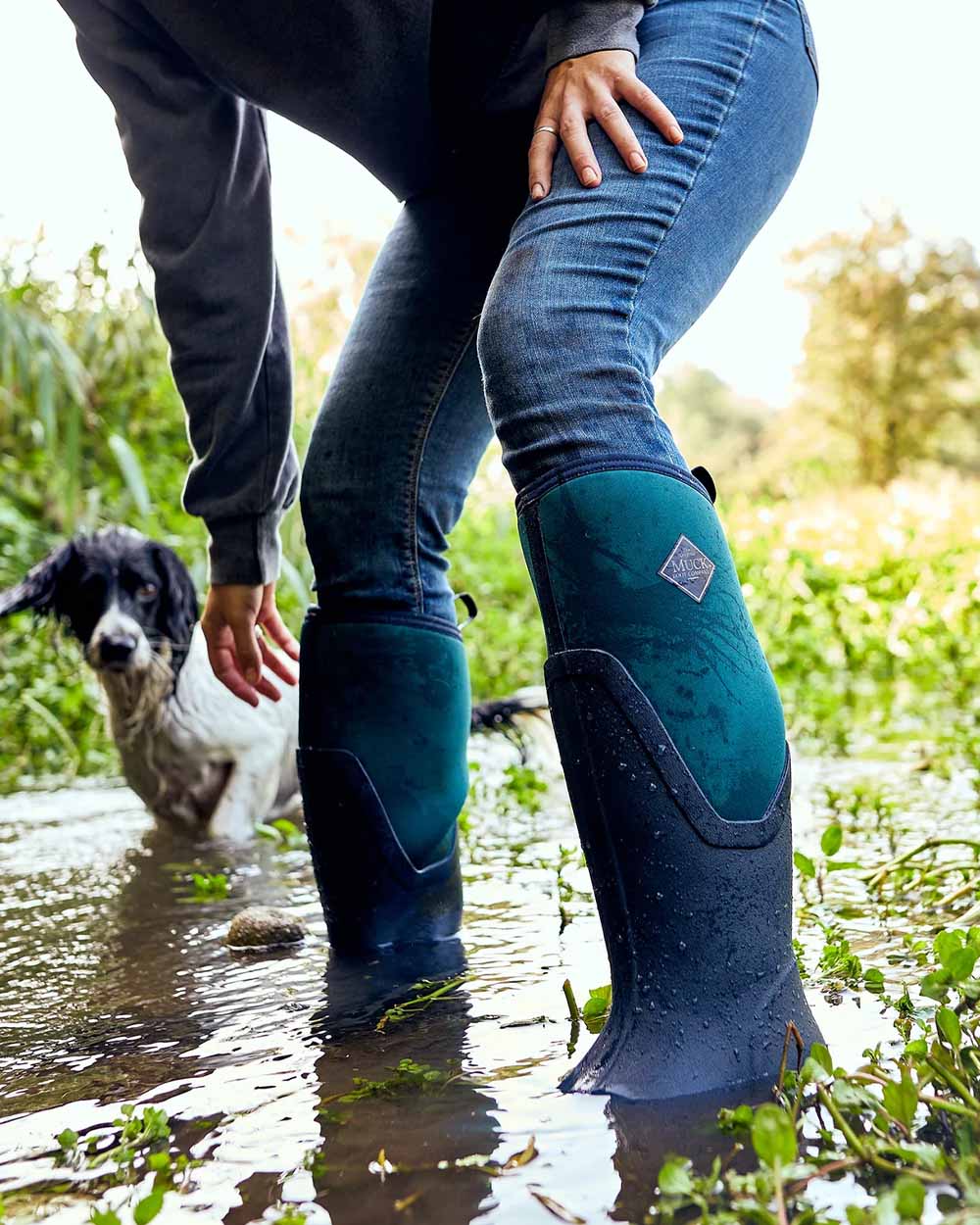 Navy/Spruce coloured Muck Boots Womens Artic Sport II Tall Wellingtons on Stream background 