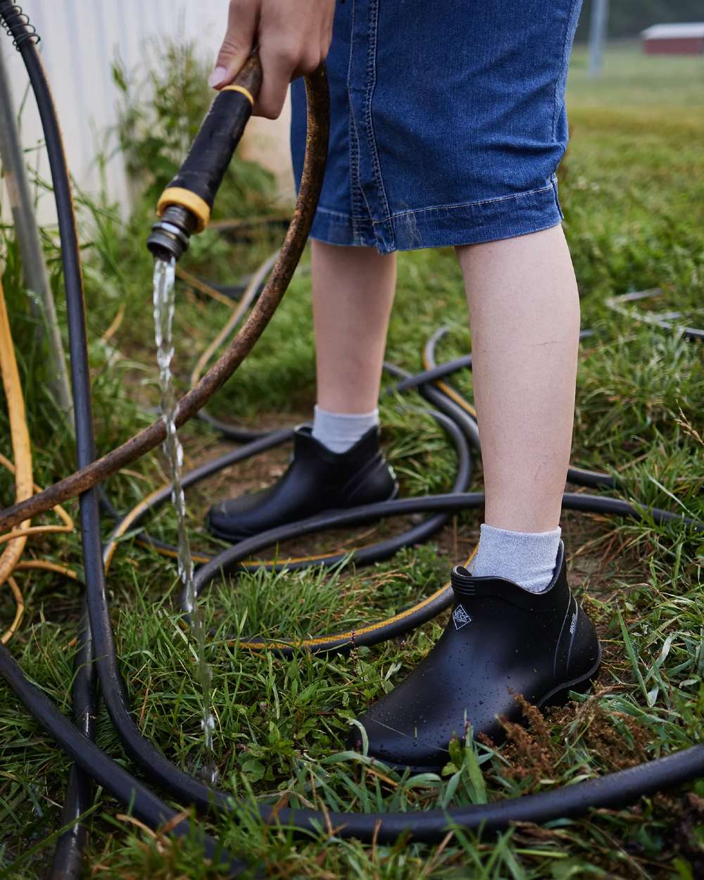 Black Coloured Muck Boots Womens Muckster Lite Ankle Boots On A Garden Background 