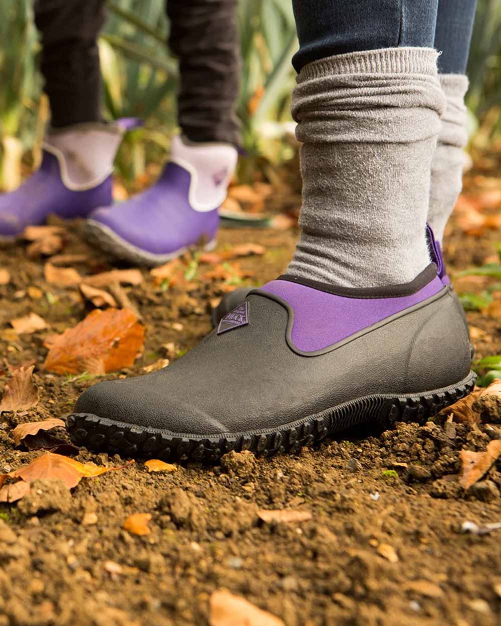 Black Purple coloured Muck Boots Womens RHS Muckster II Low Shoes on Mucky background 