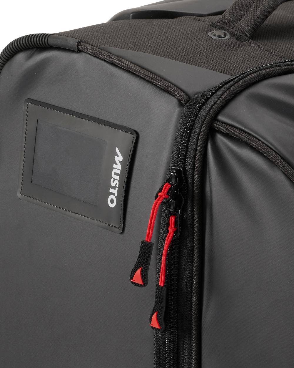 Black Coloured Musto 80L Wheeled Trolley Bag On A White Background