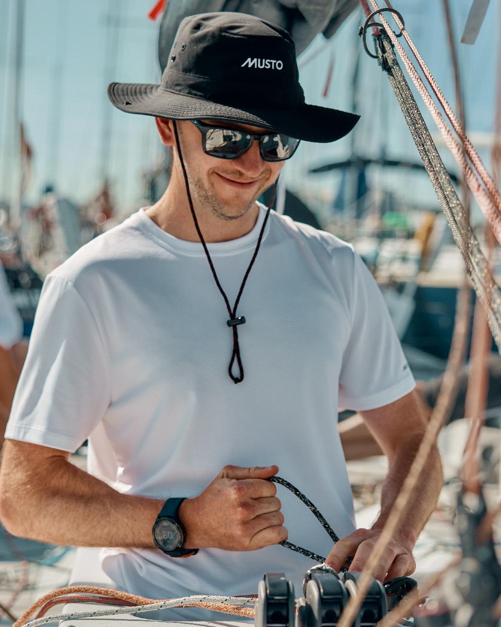 Black Coloured Musto Fast Dry Brimmed Hat on Blurry Background
