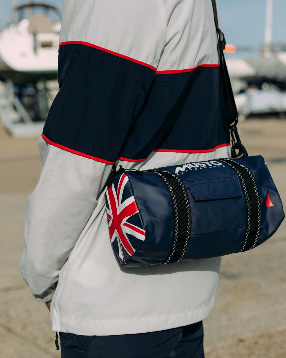 GBR Blue coloured Musto Genoa Small Carryall on Blurry Dock background 