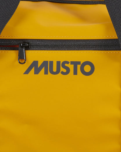 Gold Coloured Musto Genoa Small Carryall on White Background
