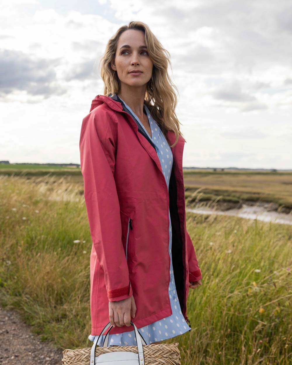 Sweet Raspberry coloured Musto Ladies Sardinia Rain Jacket on Field background 