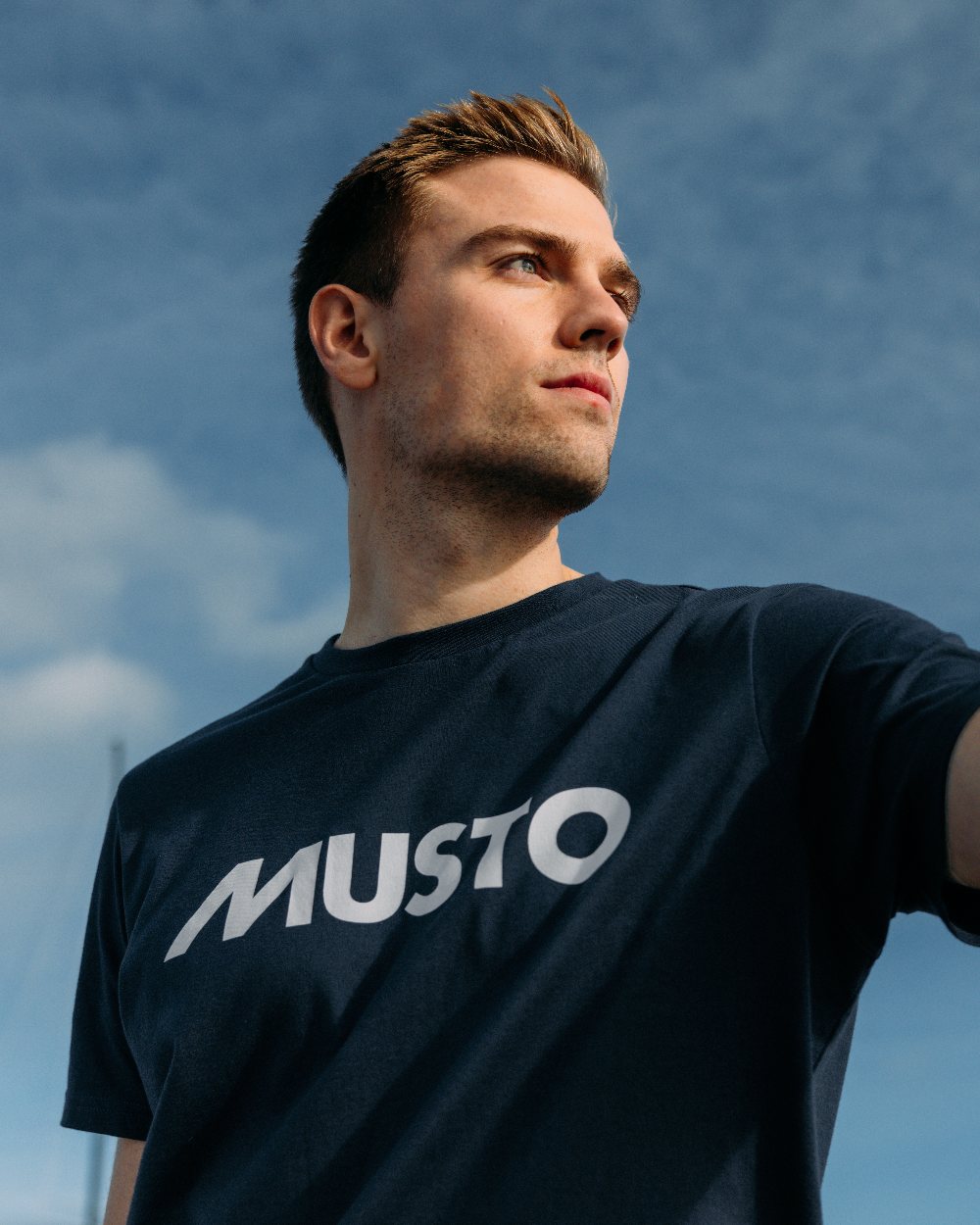 Navy Coloured Musto Logo Tee On A Sky Background 