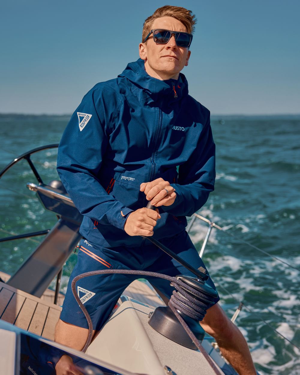 True Navy Coloured Musto Mens Br3 Sport Jacket on Sea Background

