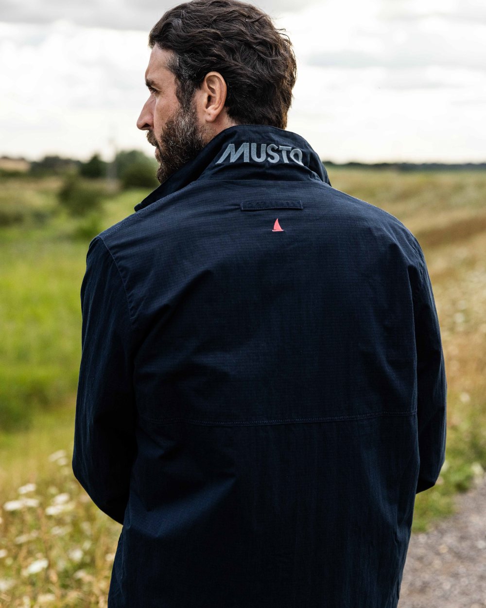 Navy Coloured Musto Mens Coastal Waterproof Jacket On A Coastal Background 