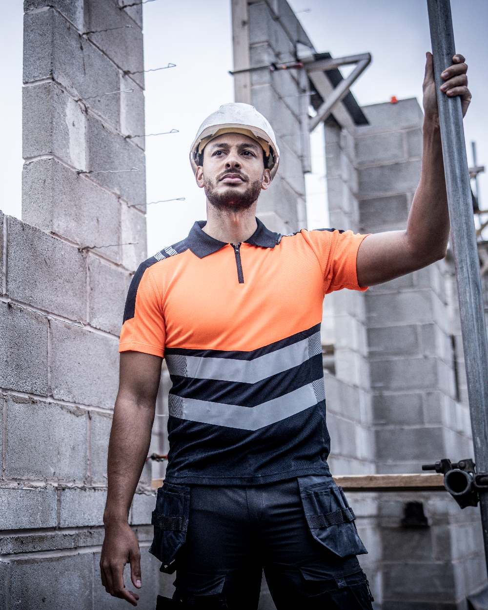 Black Orange Coloured Regatta Mens Hi-Vis X-Pro Polo Class 1 on Brick Walls Background
