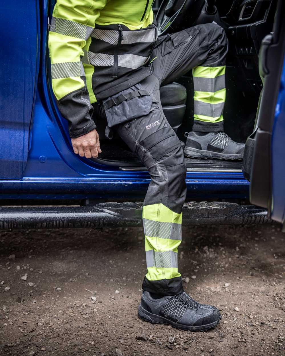 Black Yellow Coloured Regatta Mens Hi-Vis X-Pro Stretch Holster Trousers Class 1 on Outdoor Background
