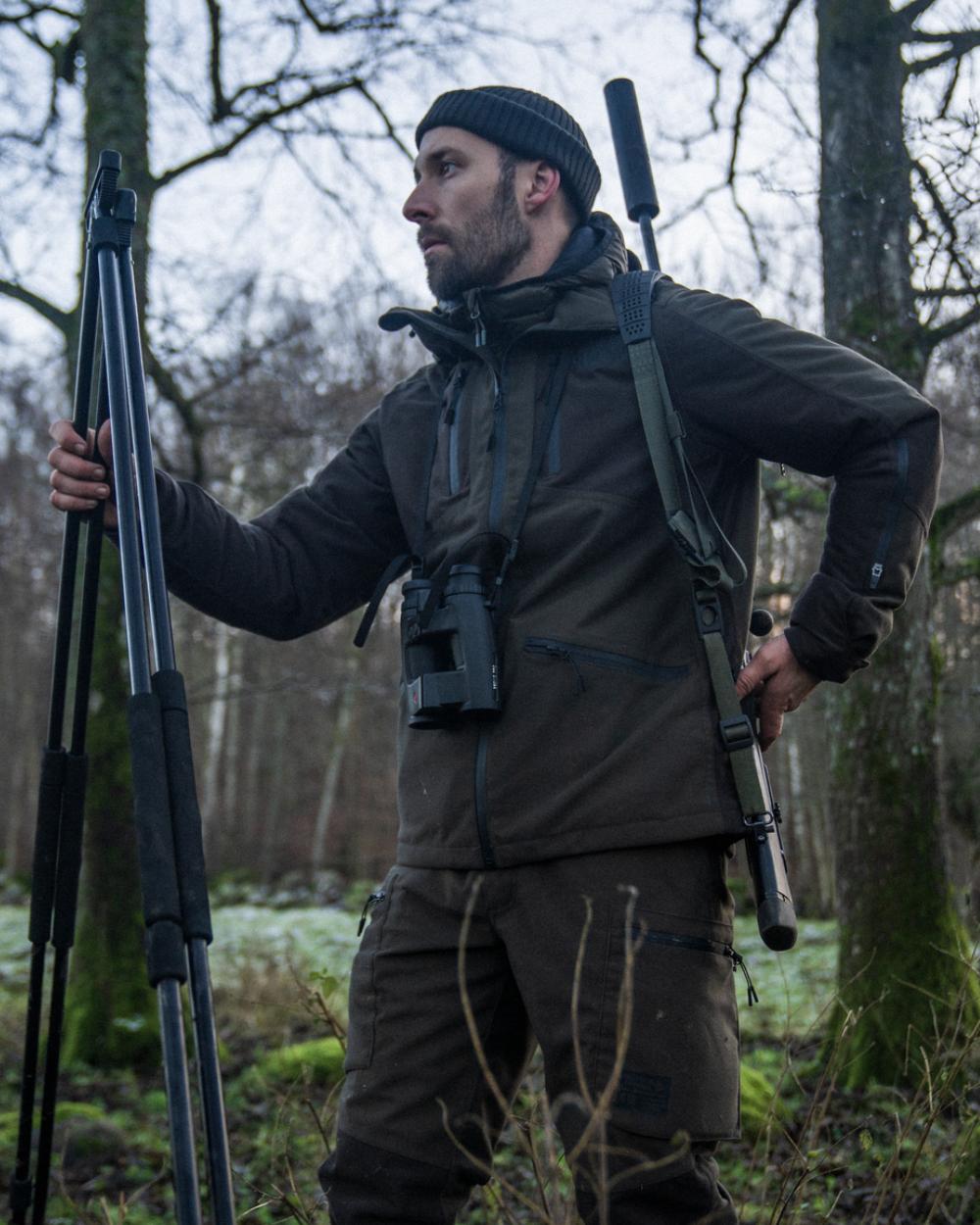 Pine Green Coloured Seeland Chaser Jacket On A Forest Background