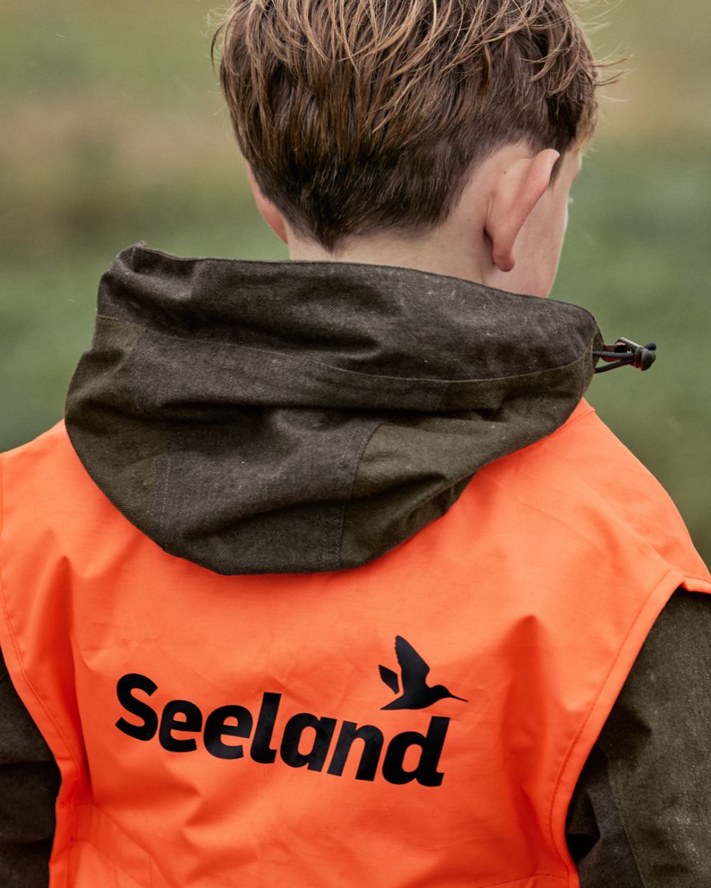 Pine Green Melange Coloured Seeland Childrens Avail Jacket On A Forest Background