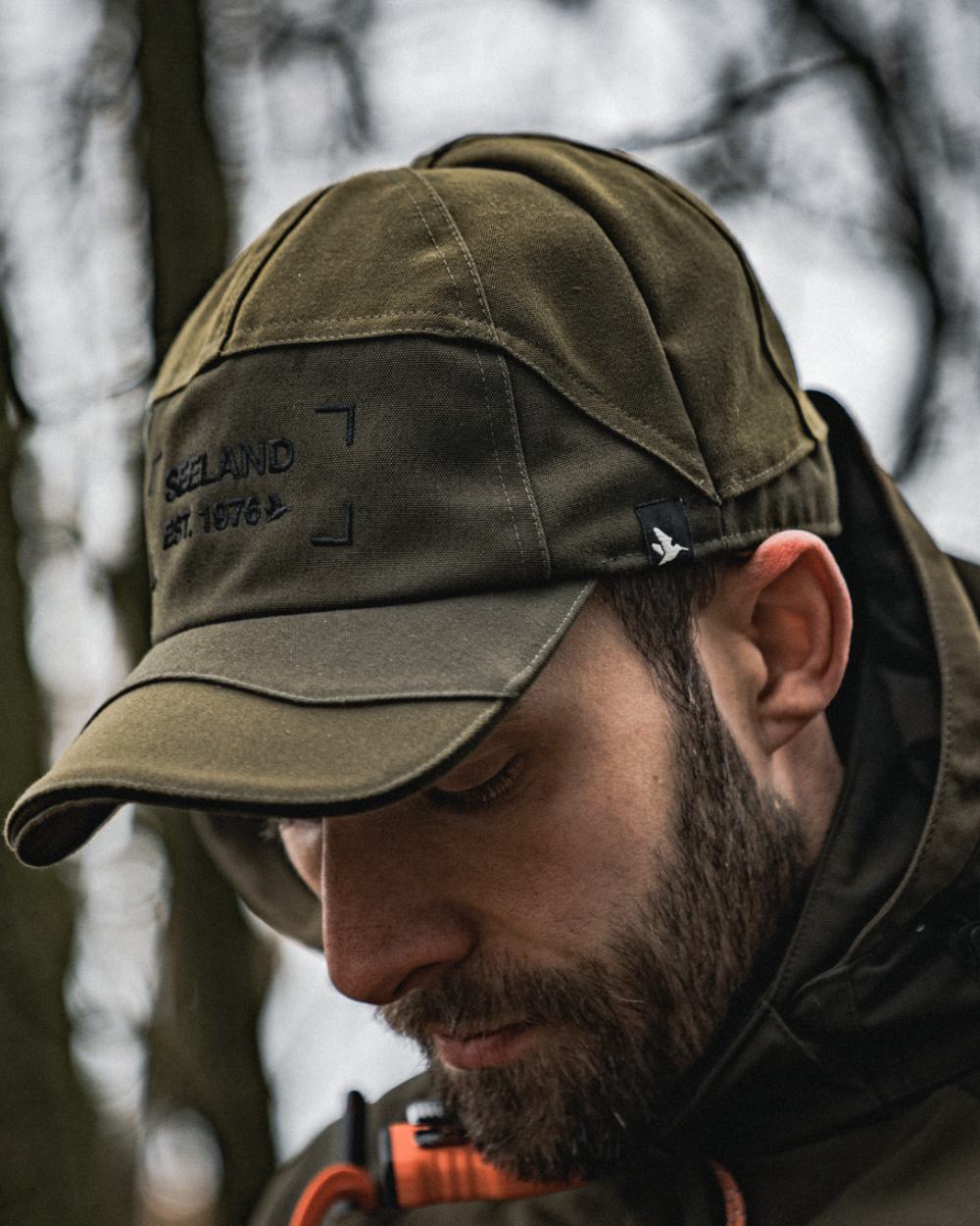 Light Pine Coloured Seeland Trax Cap On A Forest Background