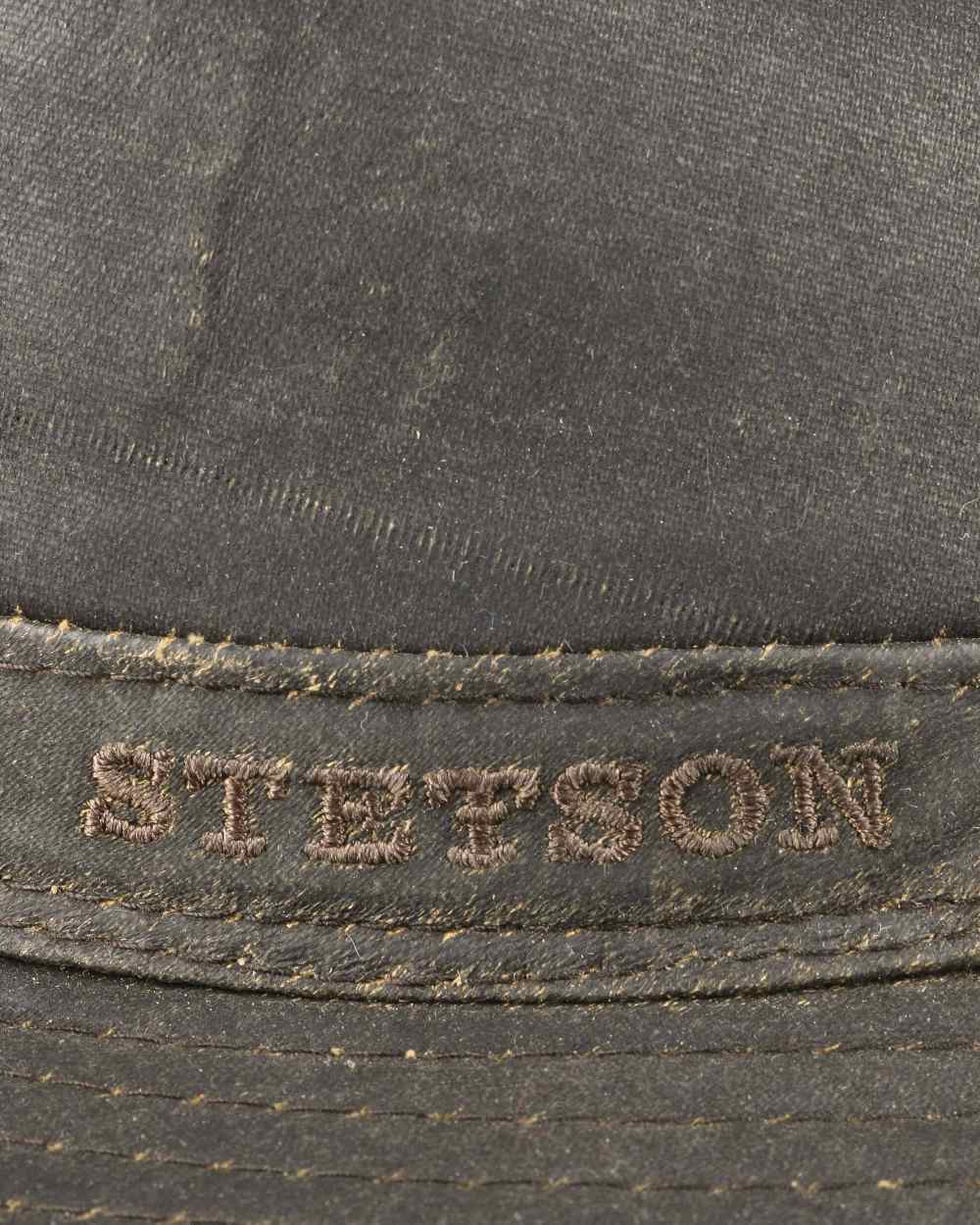 Brown Coloured Stetson Cloth Ear Flaps Traveller Hat On A White Background